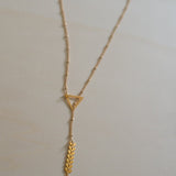 collier géométrique plaqué or fait main avec longueur réglable et pompon moutarde.